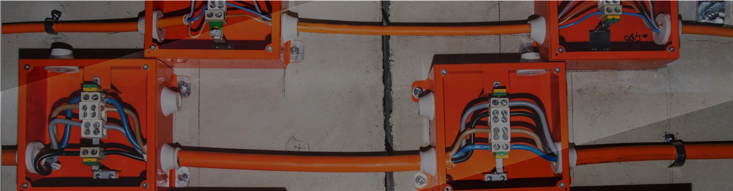 Fire resistant cables in orange protective boxes on concrete wall
